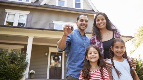 Portrait Of Family Holding Keys To New Home On Moving In Day